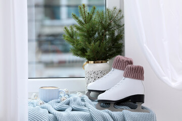 Wall Mural - Pair of ice skates and Christmas decor near window indoors