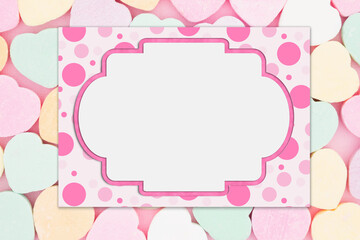 Wall Mural - Blank pink polka dot greeting card over candy hearts