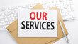 © Iryna - Text OUR SERVICES on the envelope on the keyboard