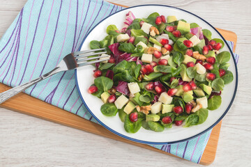 Vegetable vitamin salad with fresh young spinach leaves, mozzarella cheese, pomegranate seeds, avocado, walnuts and lemon juice. 