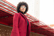 © ADDICTIVE STOCK - African American woman in crimson coat and eyeglasses