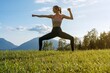 girl performs yoga exercises in a mountain meadow - outdoor gymnastics