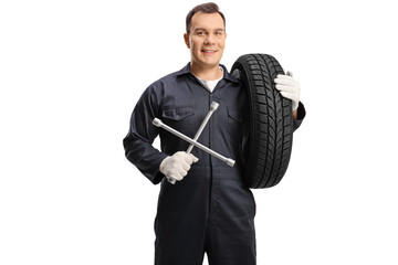 Wall Mural - Auto mechanic carrying a tire and holding a wrench tool