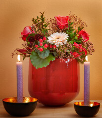 flower bouquet in a vase and two candles