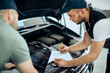 © Drazen - Two mechanics cooperate while doing car engine diagnostic at auto repair shop.