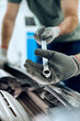 © Drazen - Close-up of mechanics collaborate while repairing car engine in workshop.