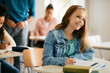 © Drazen - Smiling teenage girl takes notes during a class in high school.