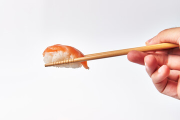 Wall Mural -  Chopsticks holding single salmon nigiri sushi isolated on white background