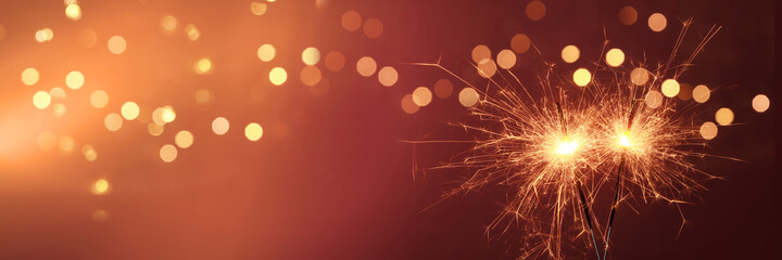 Wall Mural - Happy New Year background with glowing sparklers.