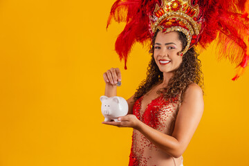 Carnival dancer woman holding a piggy bank in hands. Concept of saving for carnival