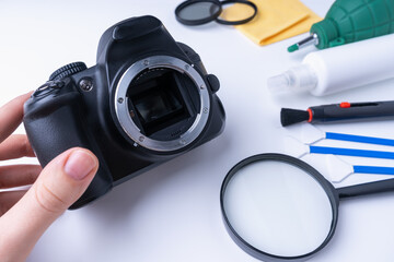 Wall Mural - The photographer holds his DSLR camera without a lens before cleaning the sensor