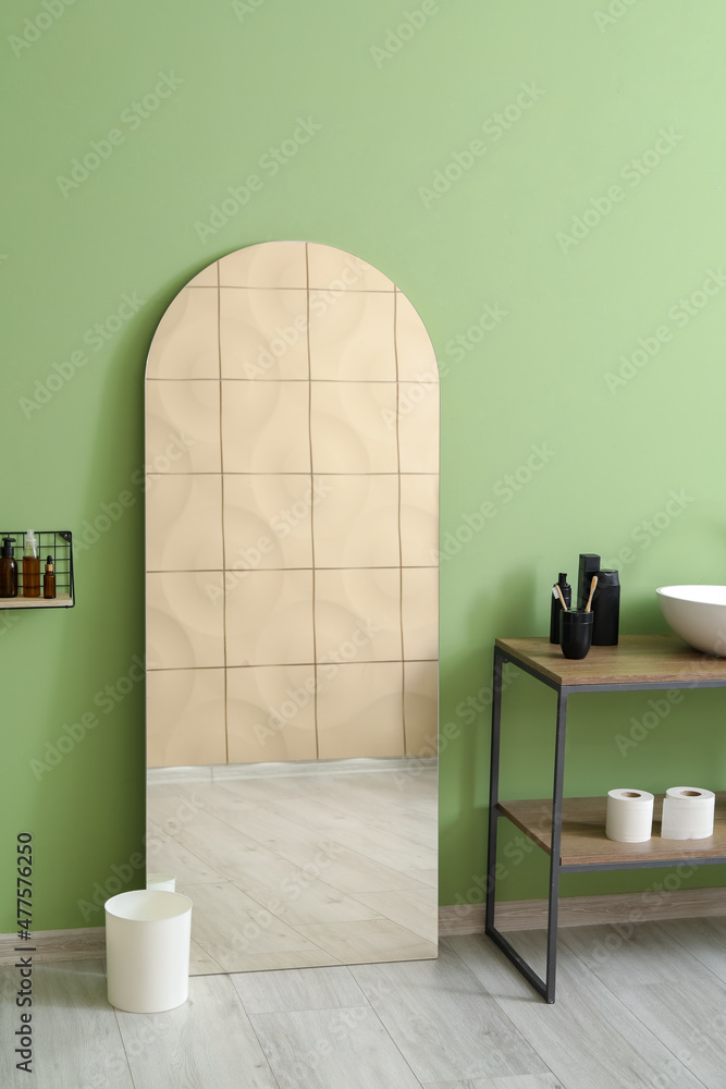 Mirror near green wall in bathroom