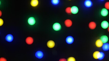 Wall Mural - christmas, holidays and illumination concept - close up of electric garland lights in dark room