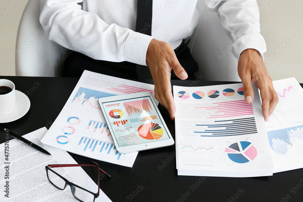 Businessman working with documents at desk in office, closeup