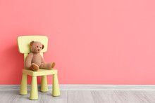 Child Chair With Cute Bear Toy Near Color Wall