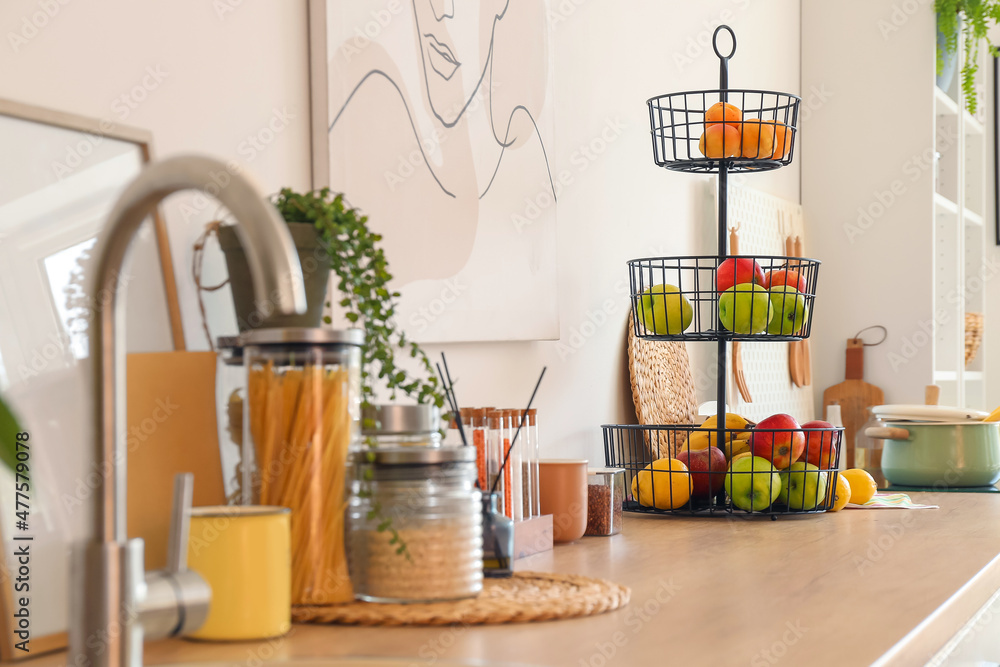Stand with healthy fruits on counter in modern kitchen