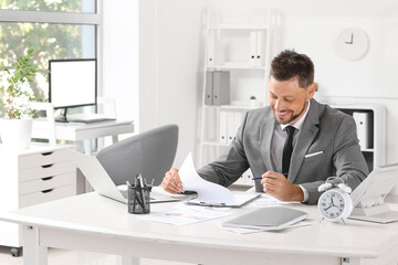 Poster - Smiling businessman working at table in office