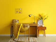 Interior Of Stylish Office With Modern Workplace, Golden Lamp And Yellow Wall