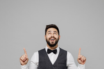 Wall Mural - Young barista male waiter butler man wear white shirt vest elegant uniform work at cafe point index finger overhead on workspace isolated on plain grey background studio. Restaurant employee concept.