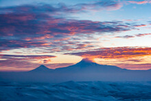The Peak Of The Mountain Is Covered With Clouds. Red Clouds At The Peak Of The Mountain During Sunset. Beautiful Sunset