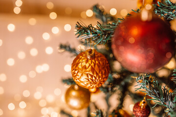 Merry christmas happy new year red color balls on Christmas tree, gold blurred shiny lights