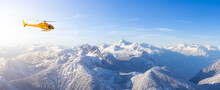 Yellow Helicopter Flying Over The Rocky Mountains. Winter Sunny Sky. Aerial Landscape From British Columbia, Canada Near Vancouver. Adventure Composite. Canadian Panoramic Nature Background