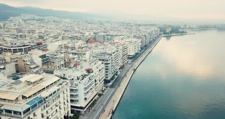 Wall Mural - Video of a drone flight over the promenade of the city of Thessaloniki with facades of buildings and a walking pedestrian path along the sea