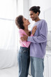 © LIGHTFIELD STUDIOS - Positive african american couple looking at each other while hugging at home.