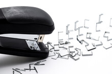 Black stapler and piles isolated on white background