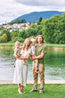 © annanahabed - Outdoor portrait of beautiful family, young couple with preschooler boy and toddler girl posing next to lake or river