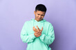 © luismolinero - Young Ecuadorian man isolated on purple background suffering from pain in hands