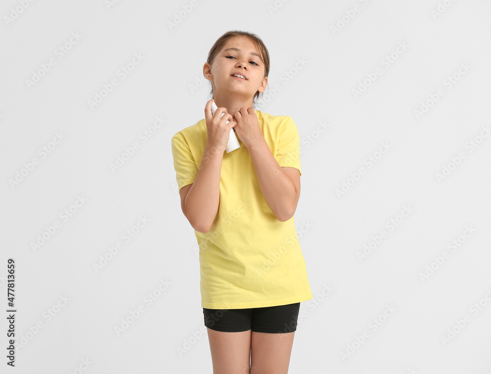 Little girl with mosquito repellent on light background