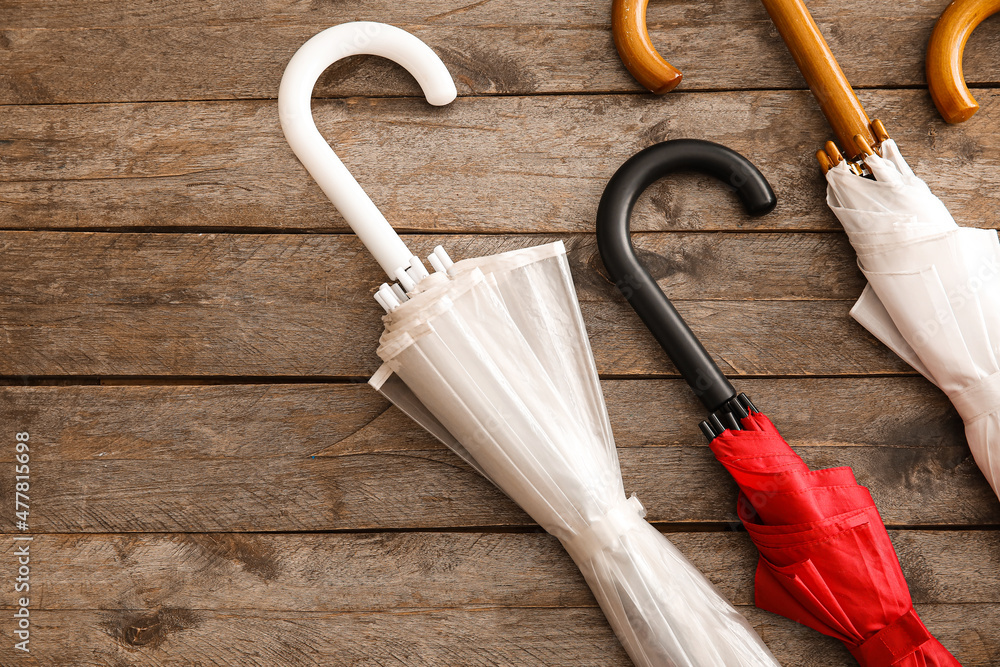 Different umbrellas on wooden background, closeup