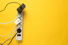 Electrical Extension Cord With Different Plugs And Adapters On Yellow Background. Top View. Copy Space