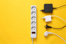 Electrical Extension Cord With Different Plugs And Adapters On Yellow Background. Top View.