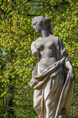 Wall Mural - Ancient decayed statue of a sensual Renaissance Era woman in the central city park of Potsdam, a German town of statues and sculptures, Germany