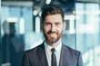 © Liubomir - Close-up portrait of businessman with beard looking at camera and smiling, man in modern office