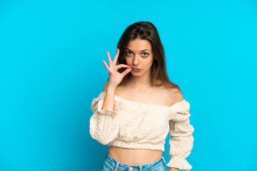 Young caucasian woman isolated on blue background showing a sign of silence gesture