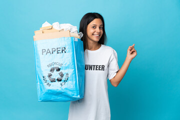 Poster - Young woman holding a recycling bag full of paper pointing back