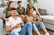 © Krakenimages.com - Group of young friends smiling happy playing video game at home.