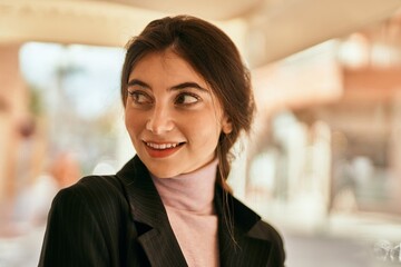 Poster - Young beautiful businesswoman smiling happy standing at the city.