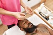 © Krakenimages.com - Young african american man having skin facial treatment at beauty center