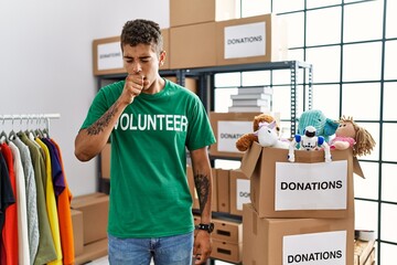 Sticker - Young handsome hispanic man wearing volunteer t shirt at donations stand feeling unwell and coughing as symptom for cold or bronchitis. health care concept.