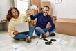 © Krakenimages.com - Middle age hispanic couple smiling happy bump fists. Sitting on the floor at new home.