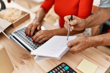 Middle age man and woman business partners working at storehouse