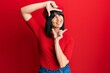 © Krakenimages.com - Young hispanic woman wearing french look with beret smiling making frame with hands and fingers with happy face. creativity and photography concept.