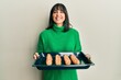 © Krakenimages.com - Young hispanic woman holding homemade bread smiling with a happy and cool smile on face. showing teeth.