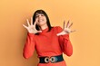 © Krakenimages.com - Young hispanic woman wearing casual clothes afraid and terrified with fear expression stop gesture with hands, shouting in shock. panic concept.
