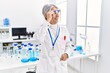 © Krakenimages.com - Middle age grey-haired woman wearing scientist uniform smiling confident at laboratory