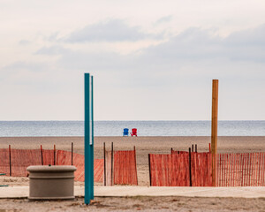 Two muskoka chairs sit on the hoirizon looking out over Lake Ontario from Balmy Beach in Toronto's iconic Beaches neighbourhood.